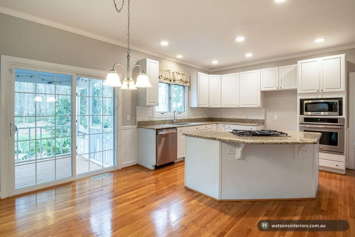 A bright, compact modern kitchen with light cabinetry, open shelving and a tidy benchtop